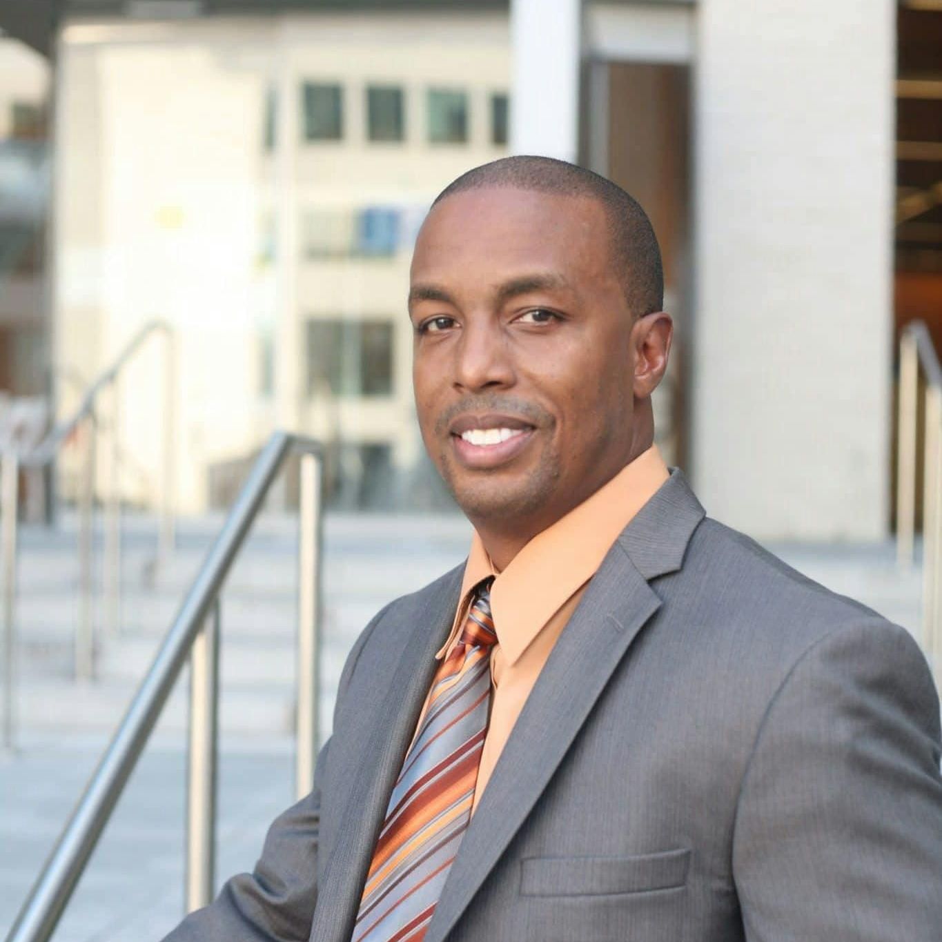 A man in a suit and tie is smiling for the camera