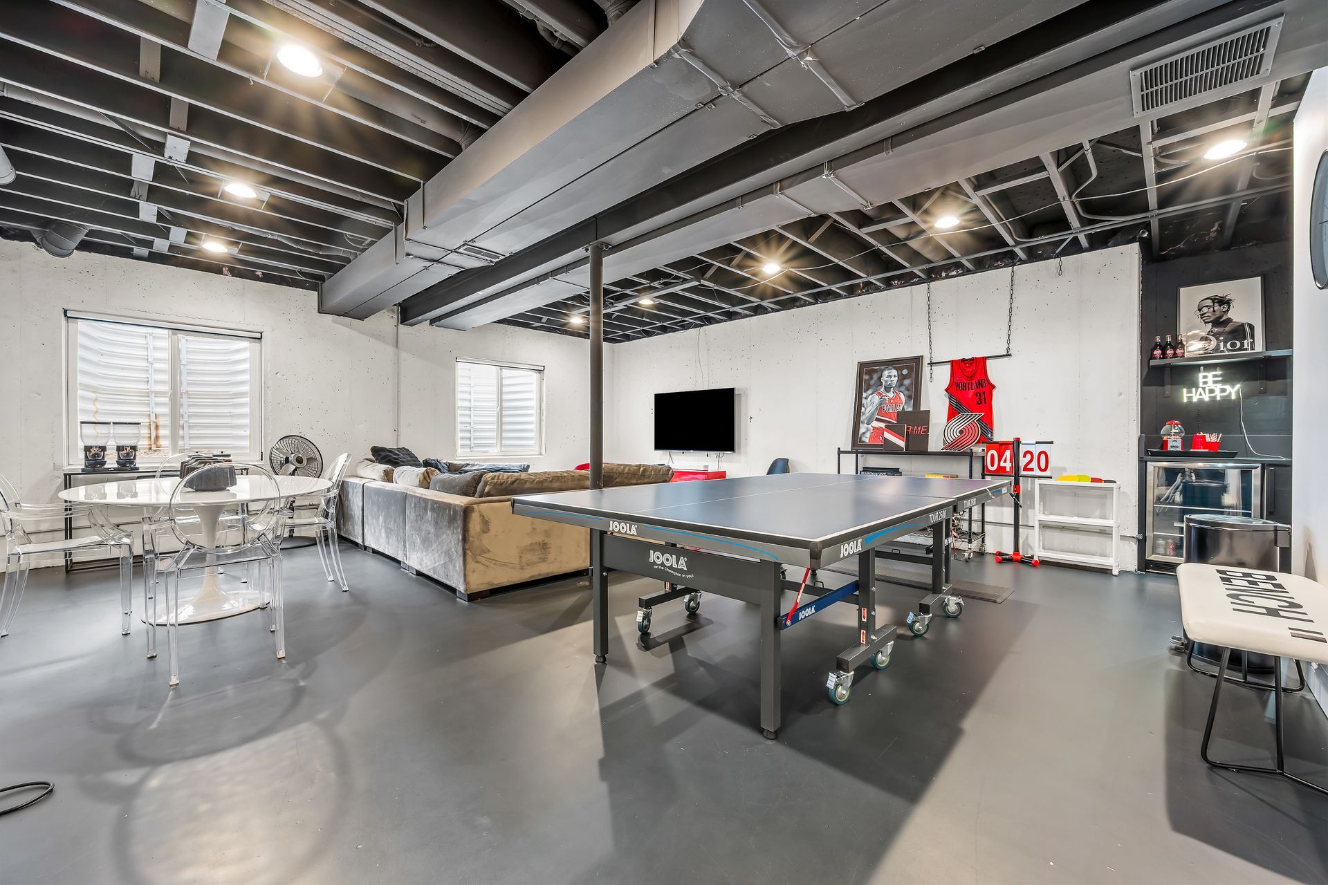 A sunlit, minimalist living room with a cream sectional sofa, marble coffee table, and large window overlooking a garden.