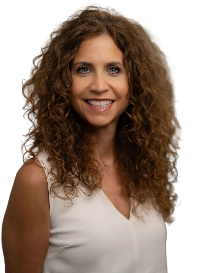 A person with long brown hair, wearing a green jacket over black, smiles against a textured grey background.