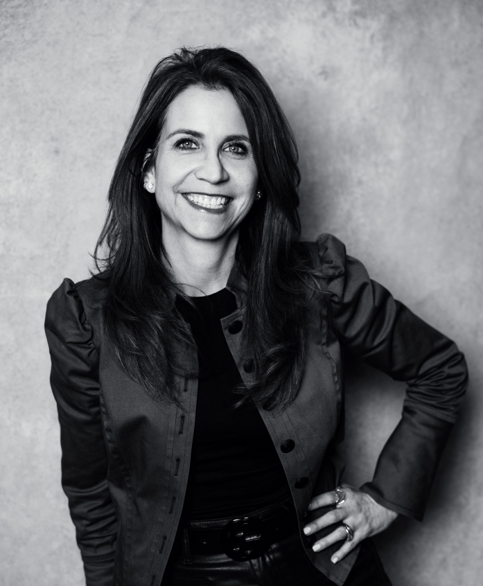 A person hands keys to another person over a signed contract and a red pen on a desk.