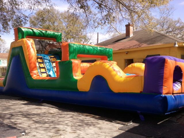 A colorful bouncy house is parked in front of a house