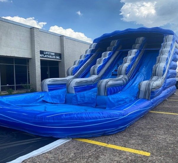 A large inflatable water slide is parked in front of a building.