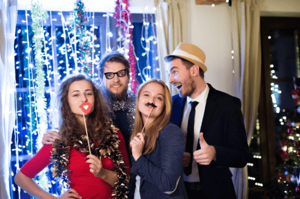 Four friends using a Photo booth at a Christmas party