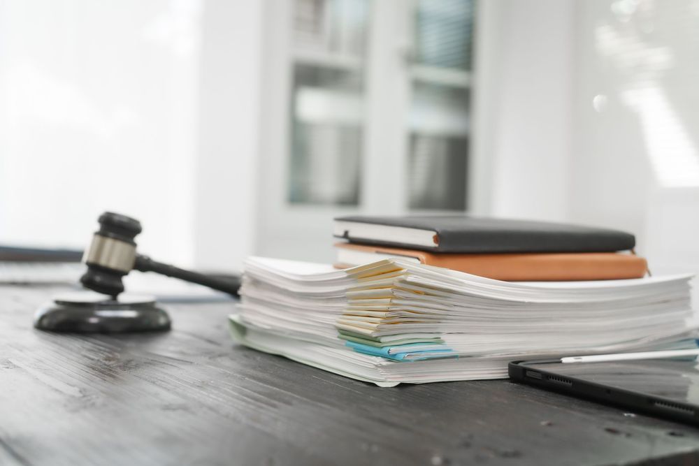 A judge 's gavel is sitting on a wooden table next to a stack of books.