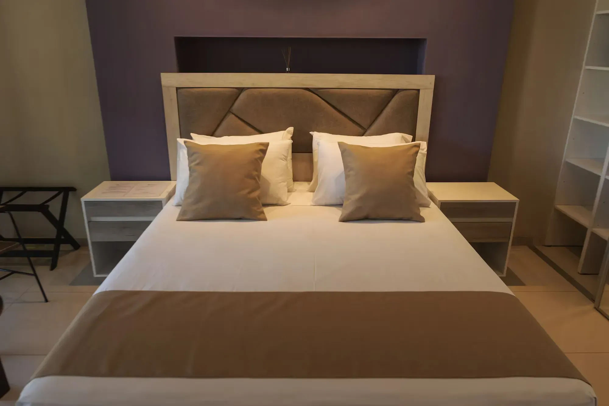 A hotel room with a bed and two nightstands
