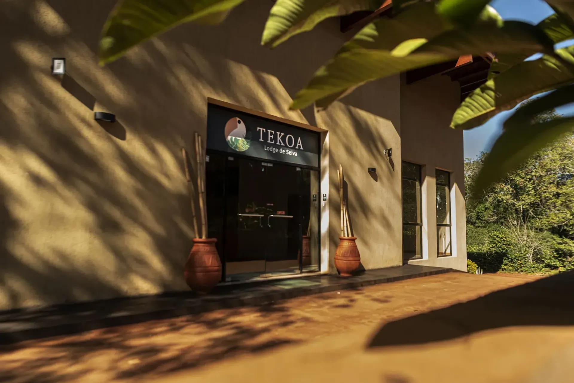 A building with a sign that says tekoa on it is surrounded by trees.