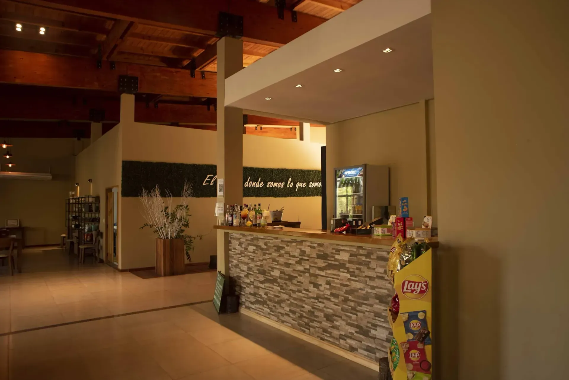 A large room with a stone wall and a pepsi machine