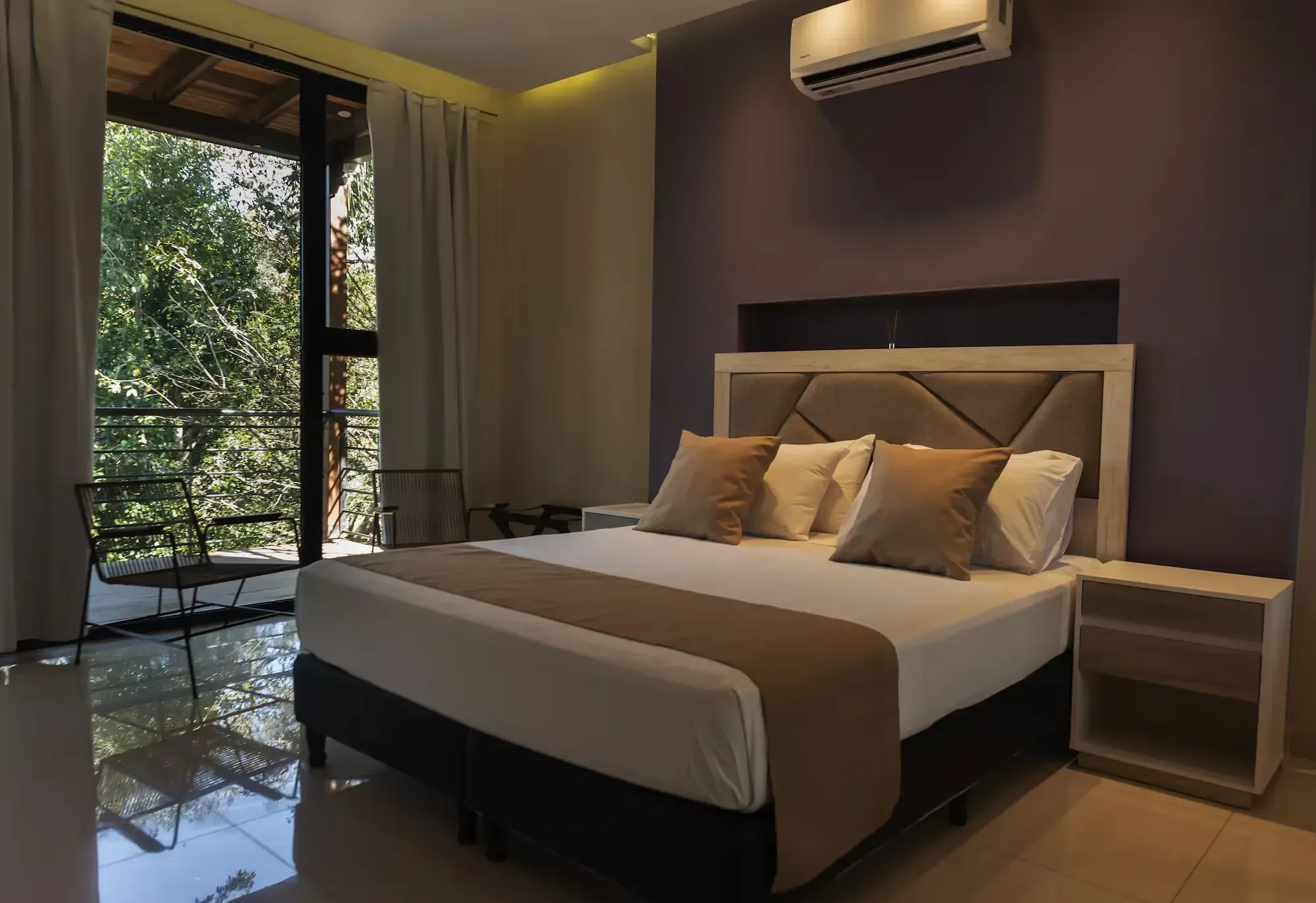 A hotel room with a king size bed and a balcony