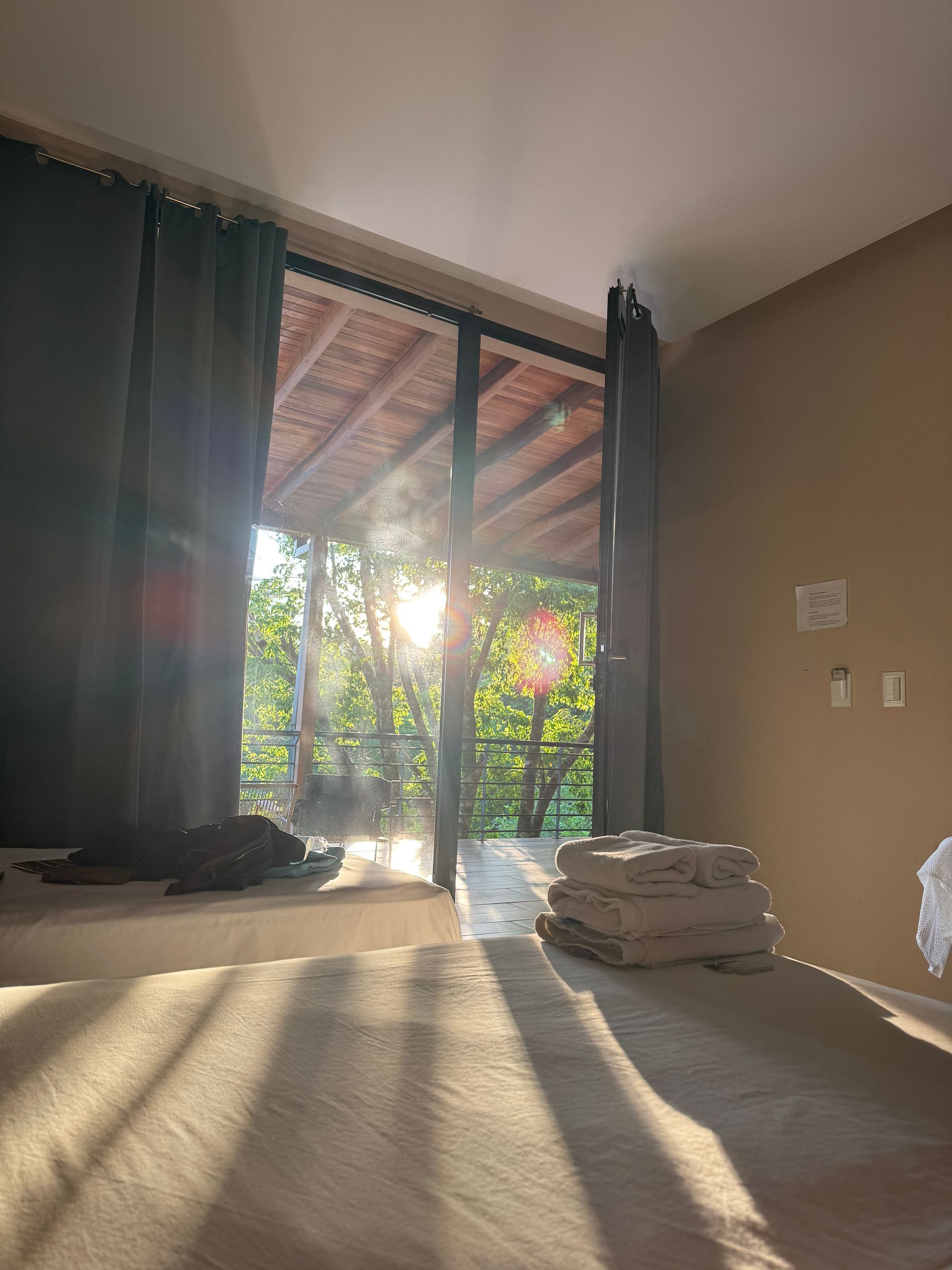The sun is shining through the windows of a bedroom.