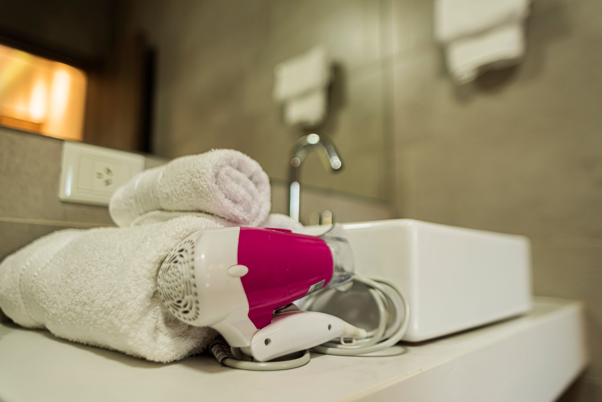 A bathroom sink with towels and a hair dryer on it.