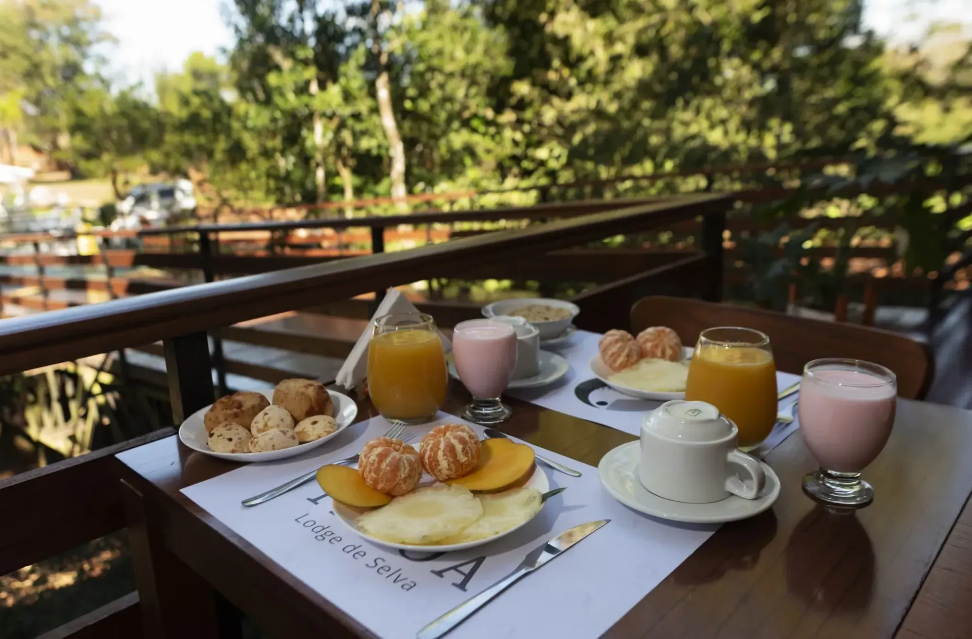 A table topped with plates of food and drinks on a balcony.