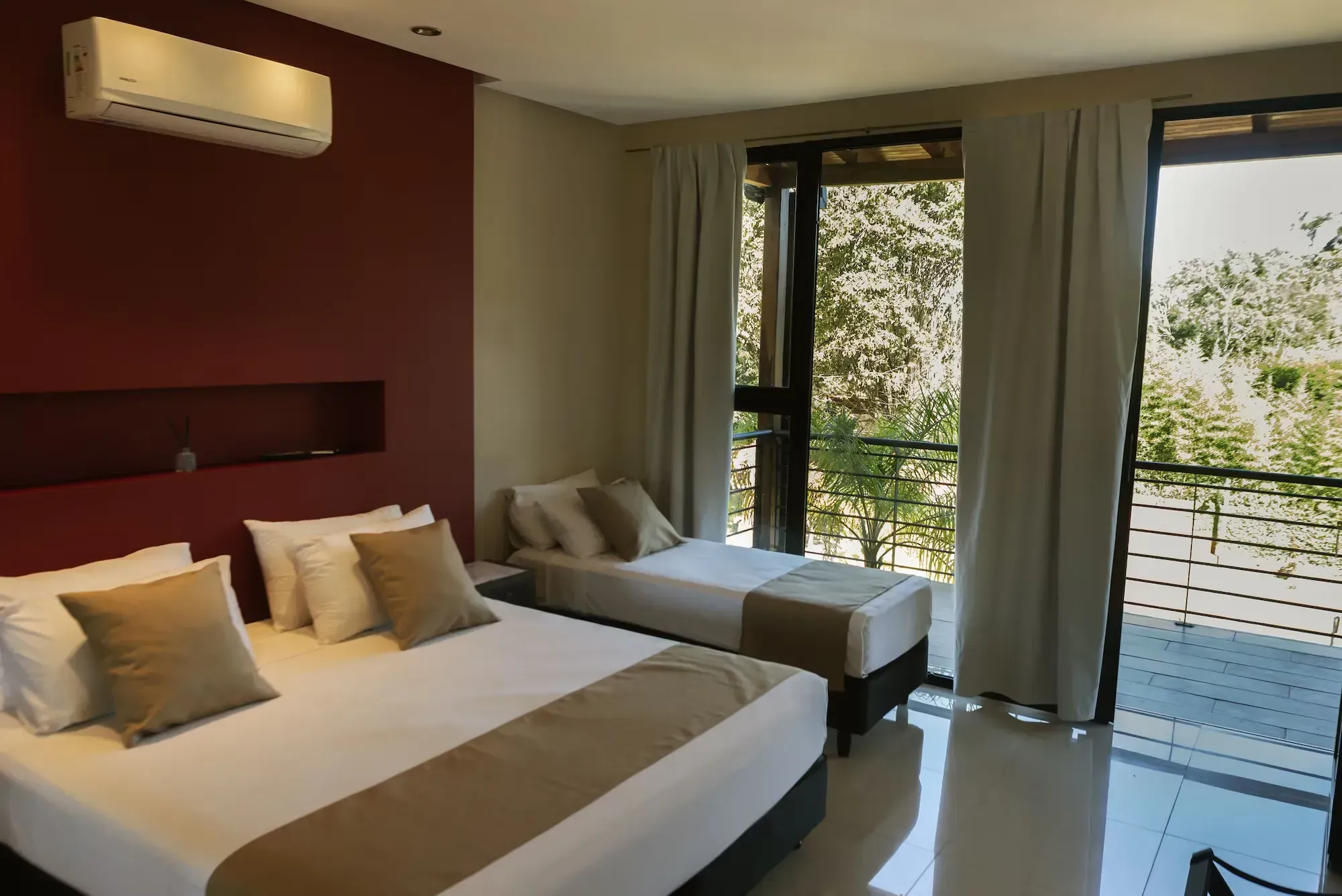 A hotel room with two beds and a balcony