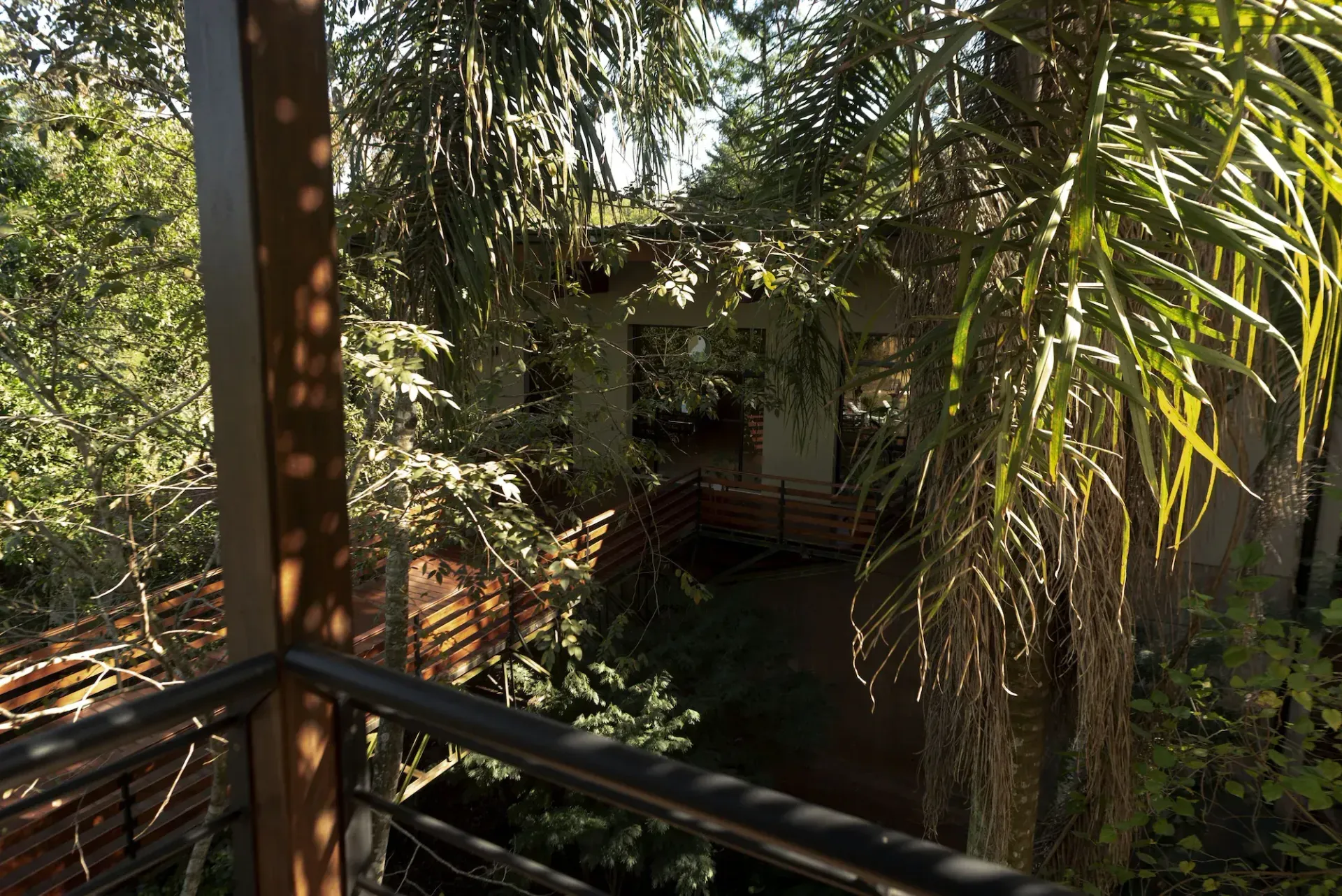 A balcony with a view of a house surrounded by trees