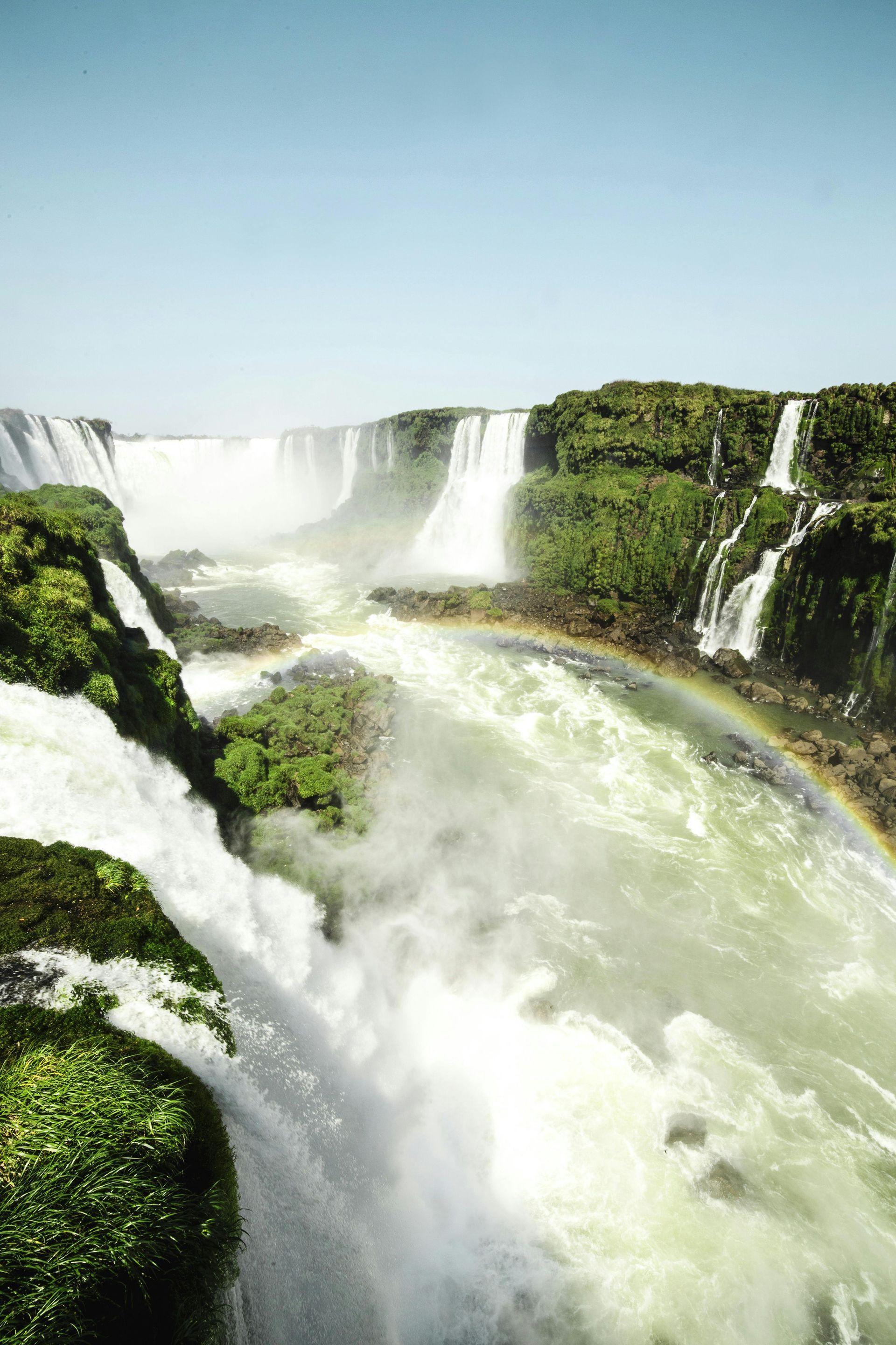A waterfall with a rainbow in the middle of it