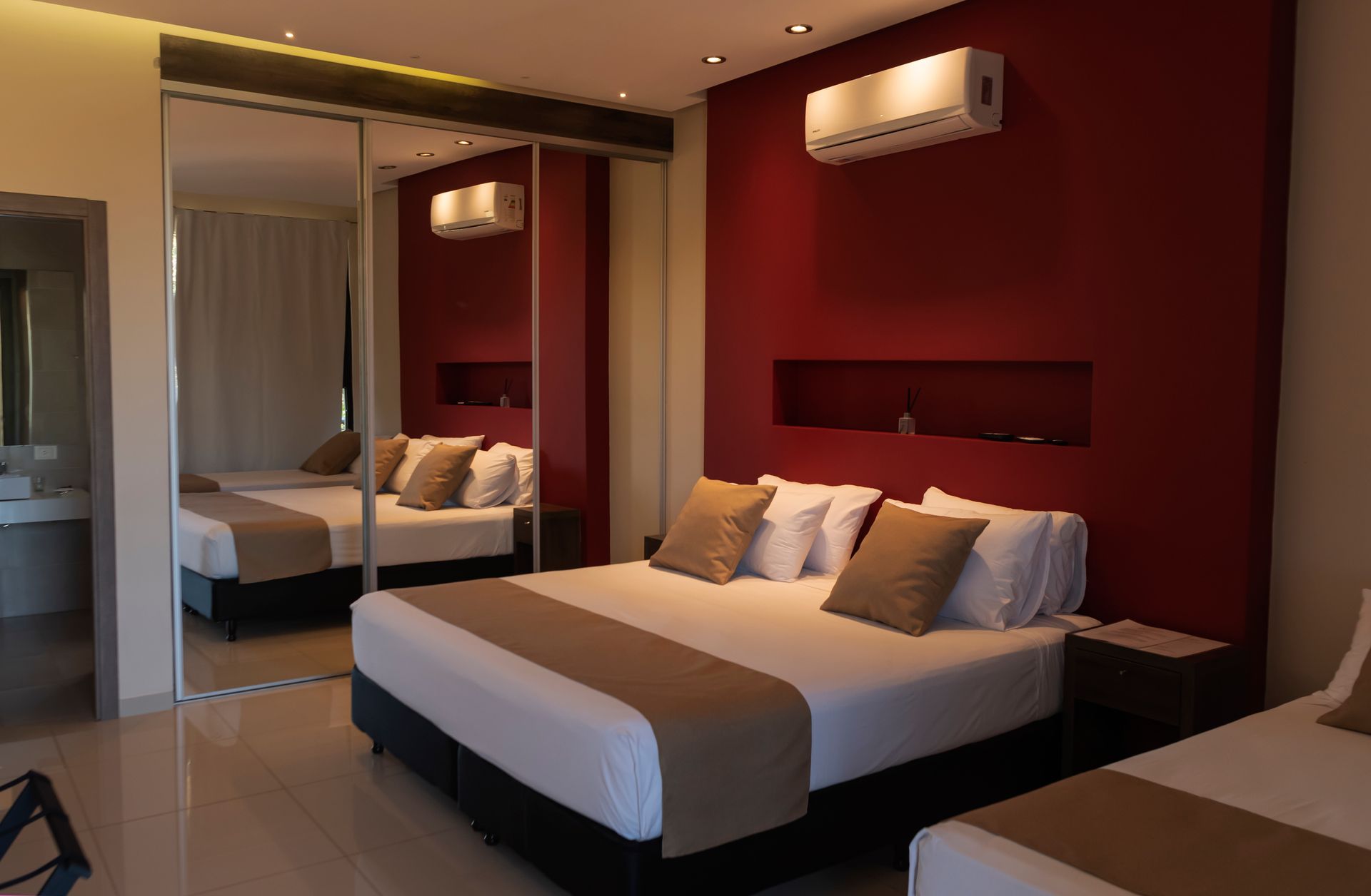 A hotel room with a king size bed and two twin beds.