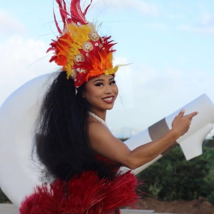 A woman wearing a red and yellow feathered headdress