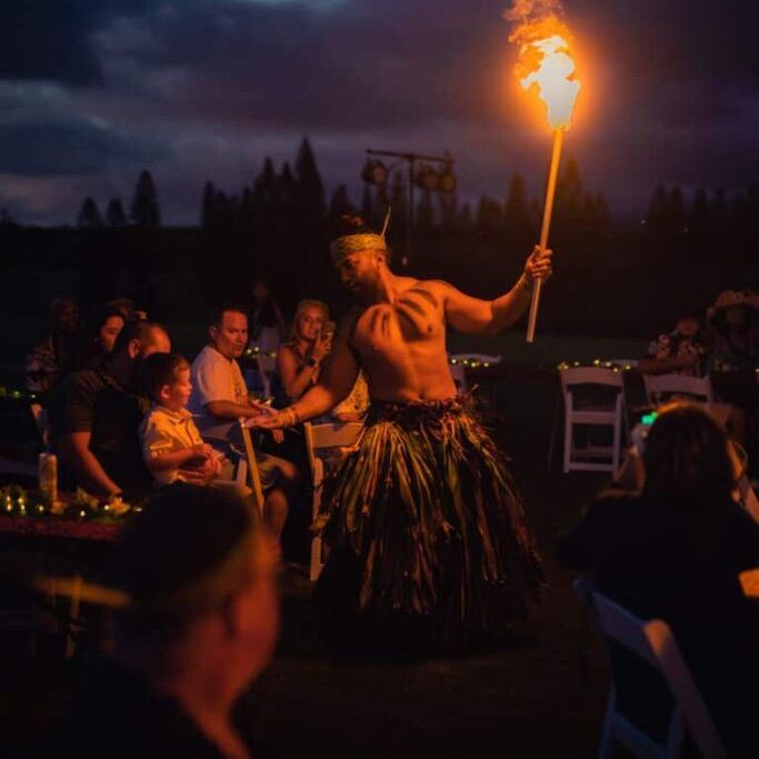 A man is holding a torch in front of a crowd of people.