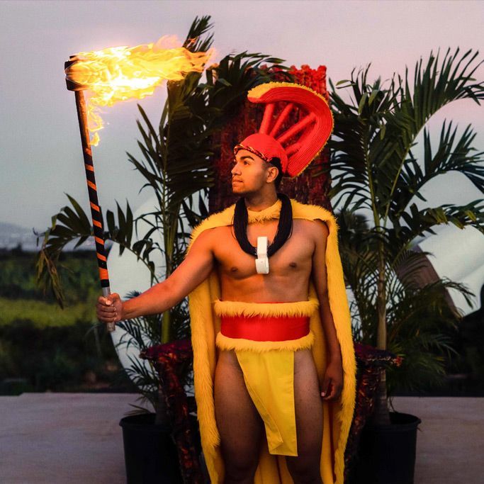 A man in a yellow and red outfit is holding a torch