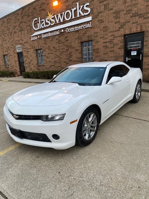 White Chevrolet Camaro parked in front of a brick building with