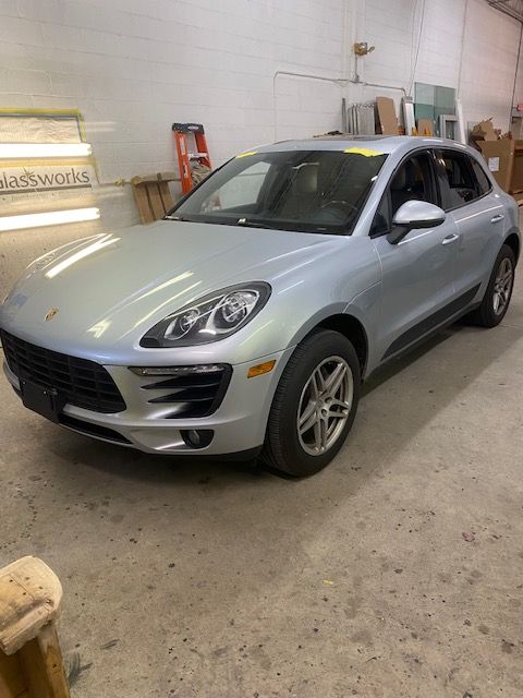 Silver Porsche Macan SUV parked inside a building, with a ladder visible in the background.
