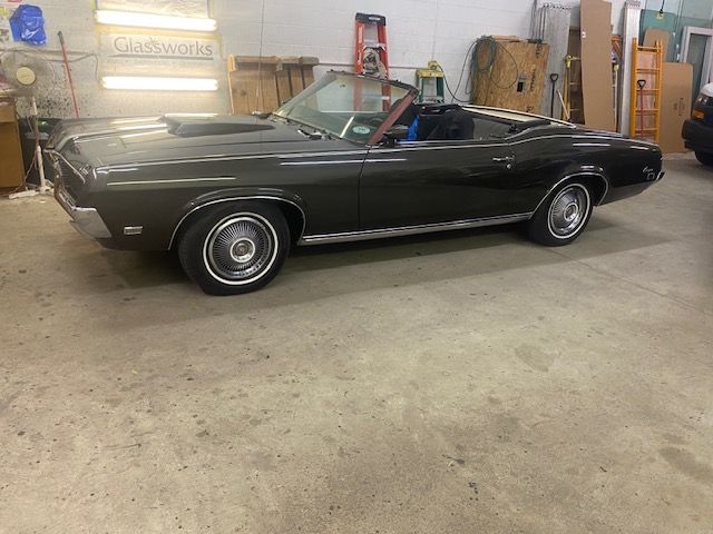 Dark green 1968 Mercury Cougar convertible parked in a garage.