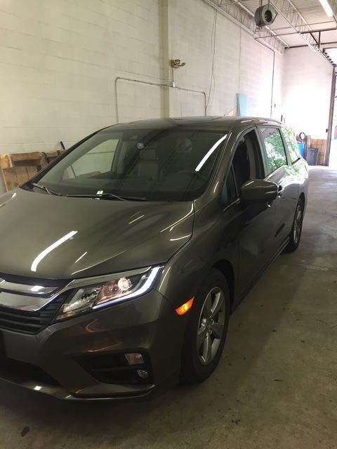 Gray Honda Odyssey minivan parked inside a garage.