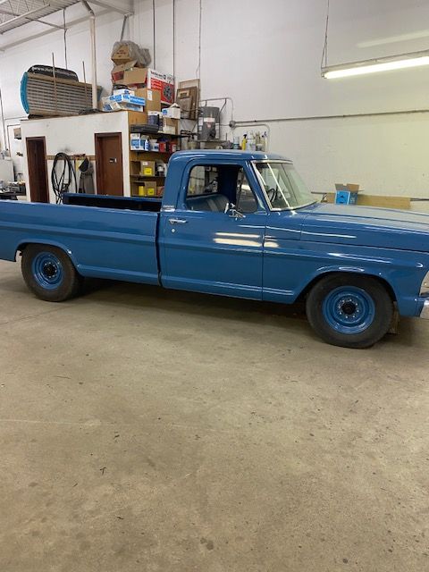 Blue vintage pickup truck in a garage.
