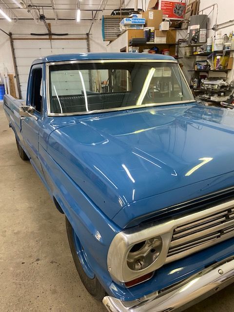 Blue vintage Ford pickup truck in a garage.