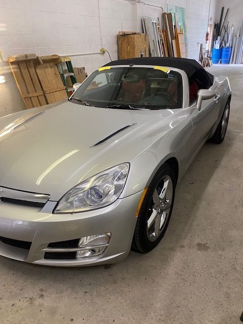 Silver Saturn Sky convertible in a garage.