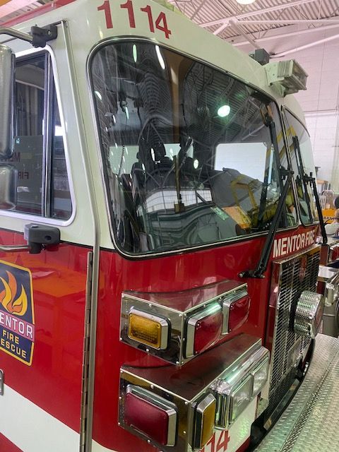 Fire truck, red and white, parked in a garage, displays the number 1114 and