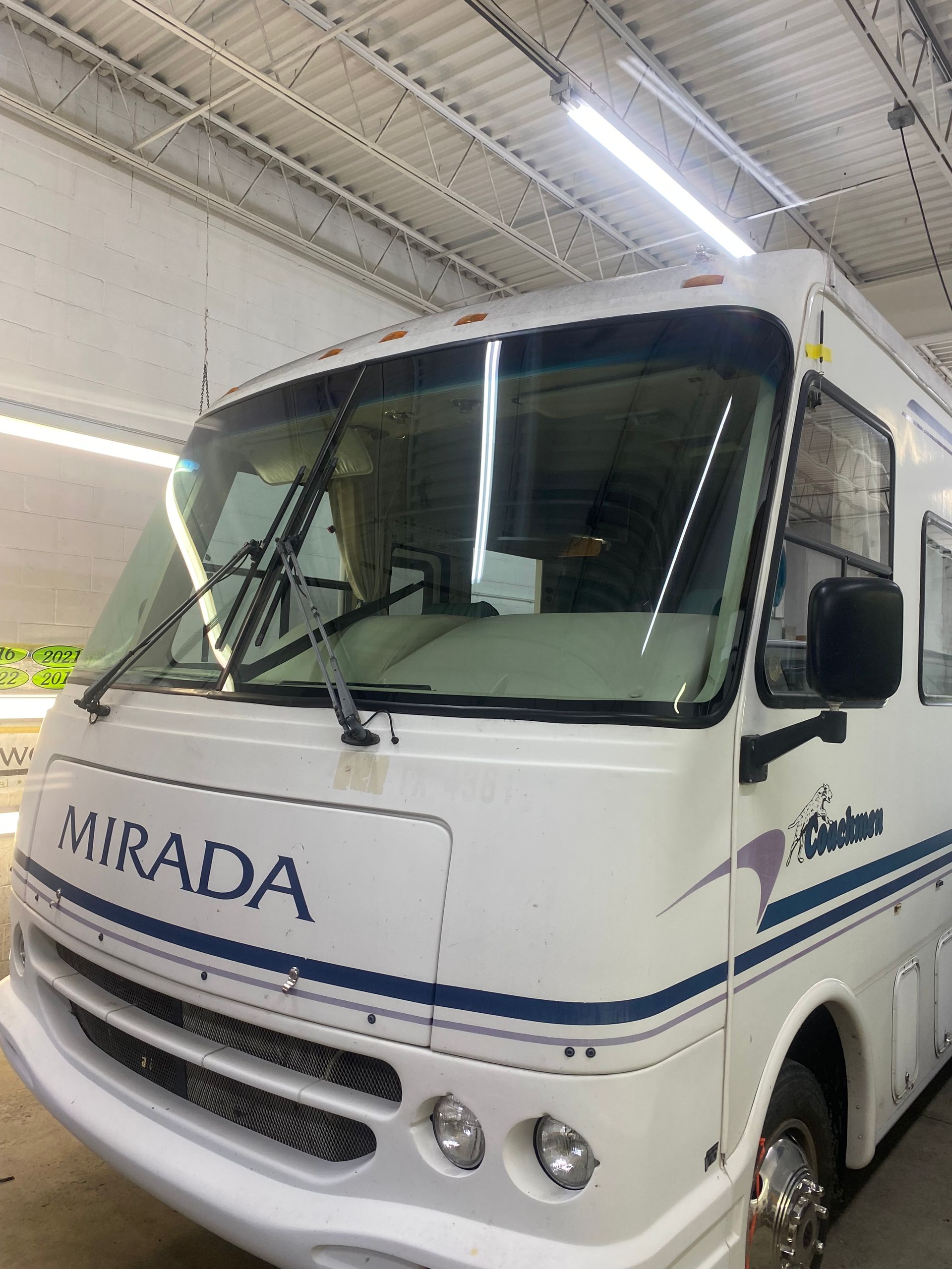 White Mirada motorhome parked indoors with wipers up.