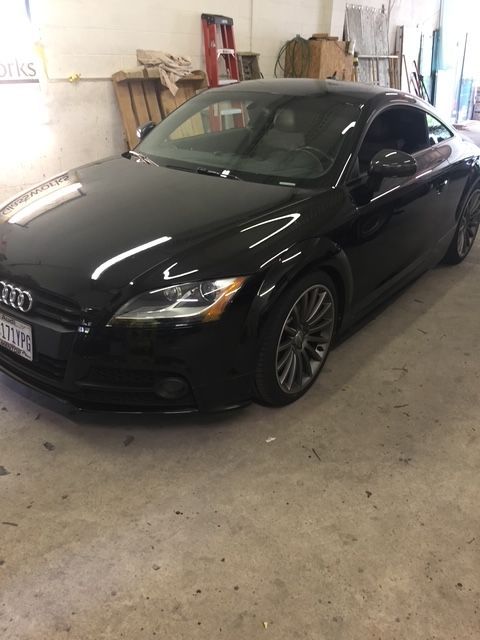 Black Audi TT coupe parked inside a garage.