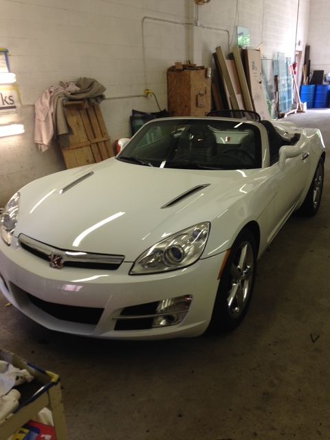 White Saturn Sky roadster in a garage.