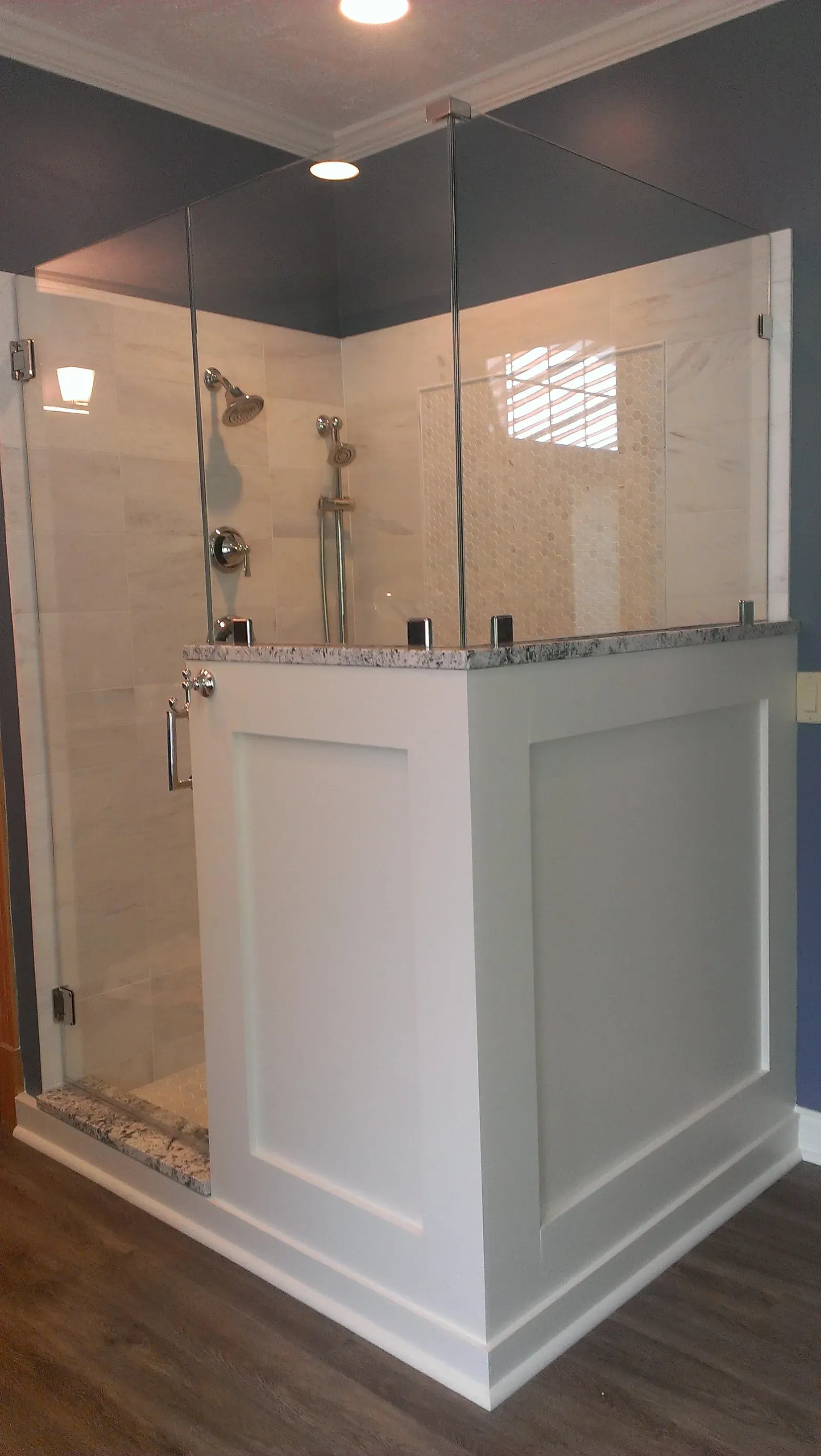 A modern white and gray bathroom with a glass-enclosed shower.