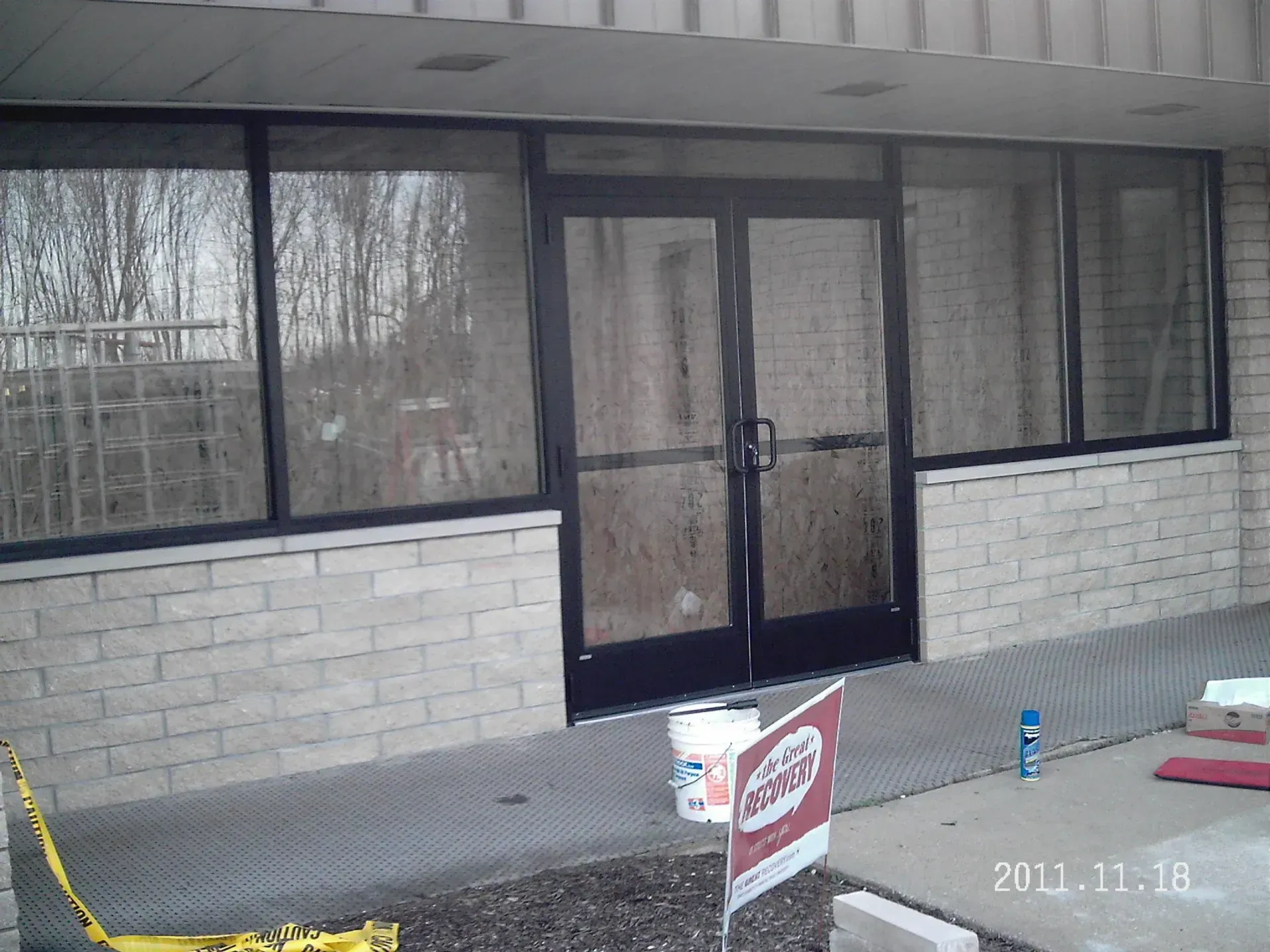 Exterior entrance with brick facade, black framed doors, and a wheelchair ramp.