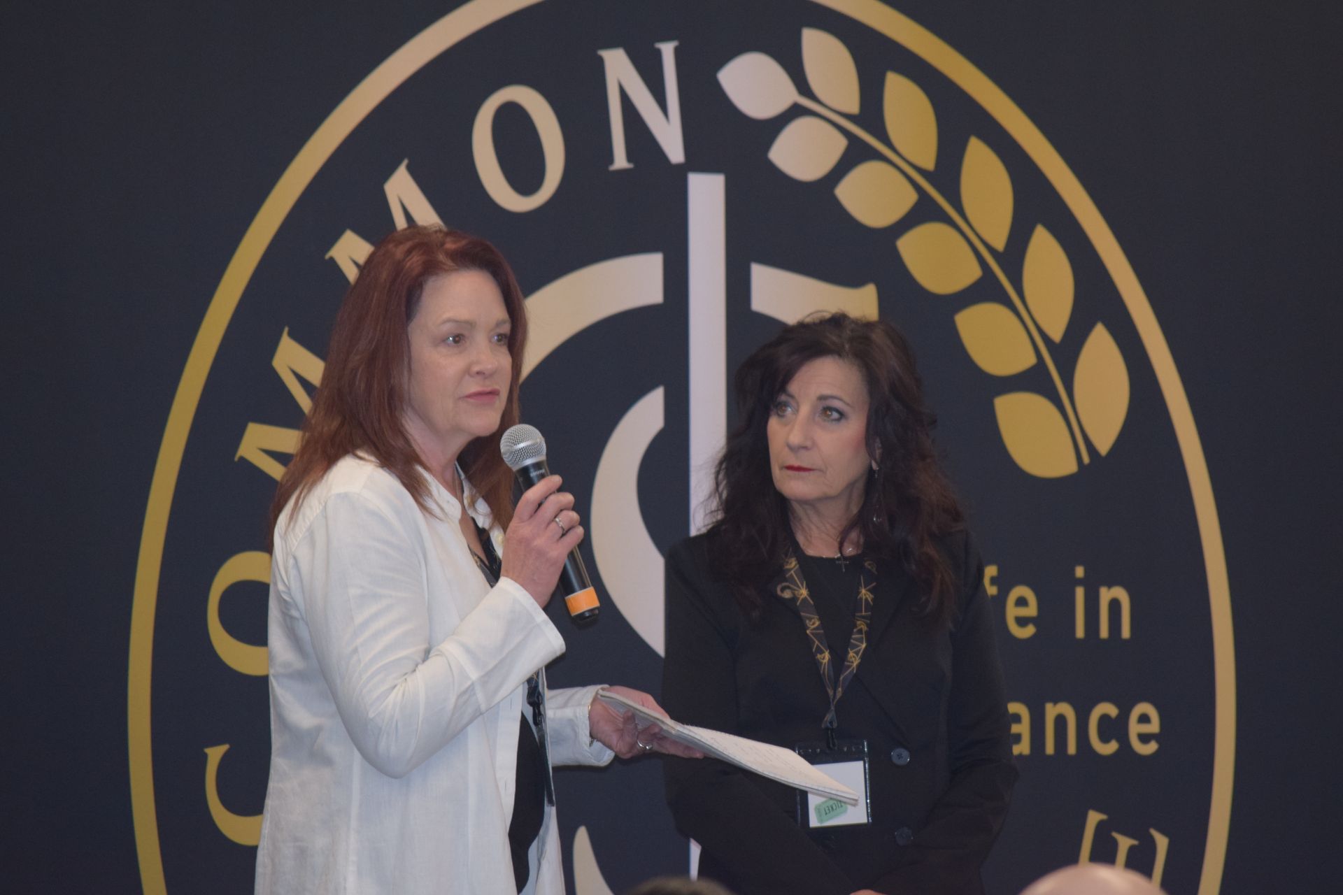 Two women standing in front of a masonic logo