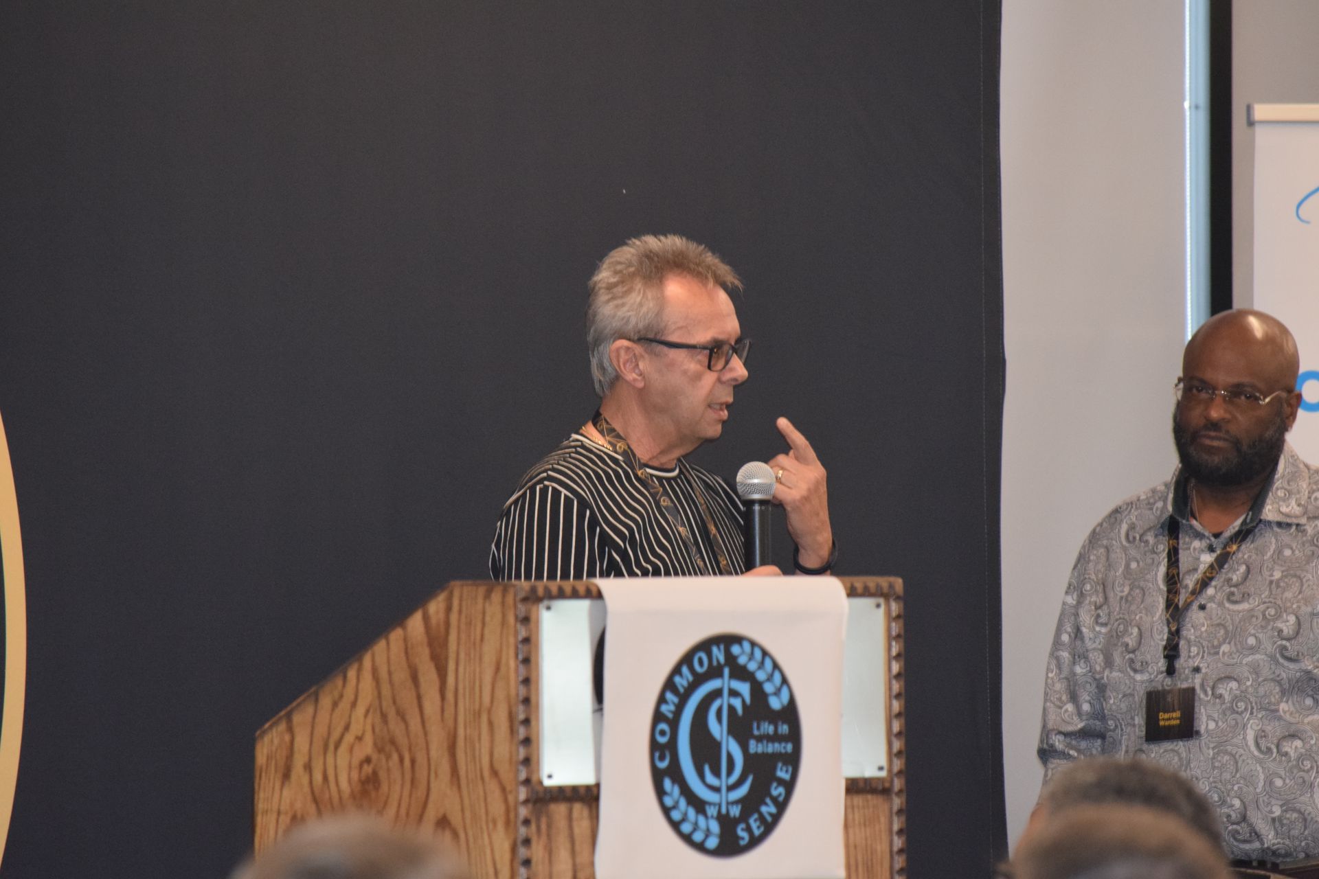 A man is standing at a podium talking into a microphone.