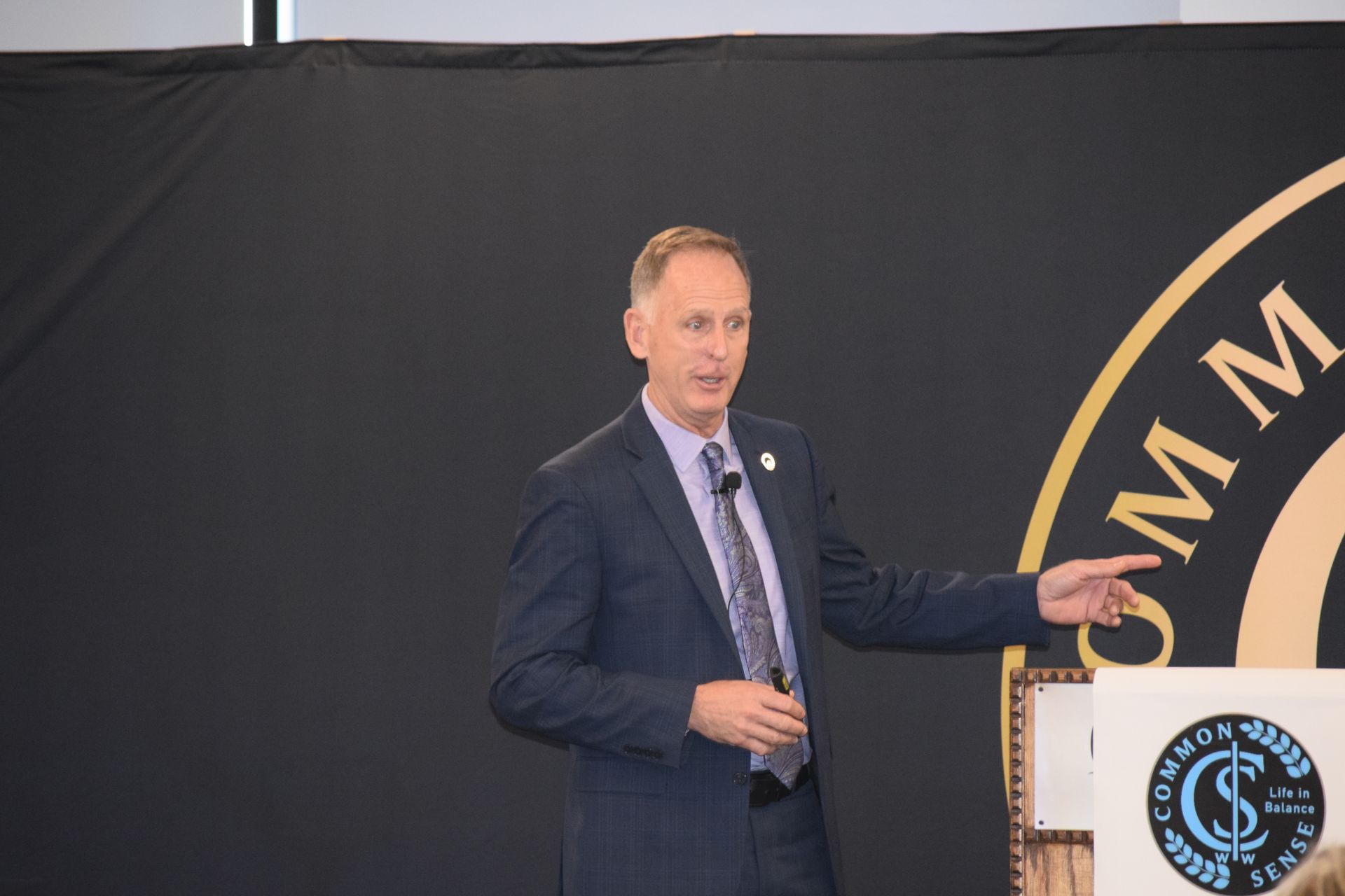 A man in a suit and tie is giving a speech at a podium.
