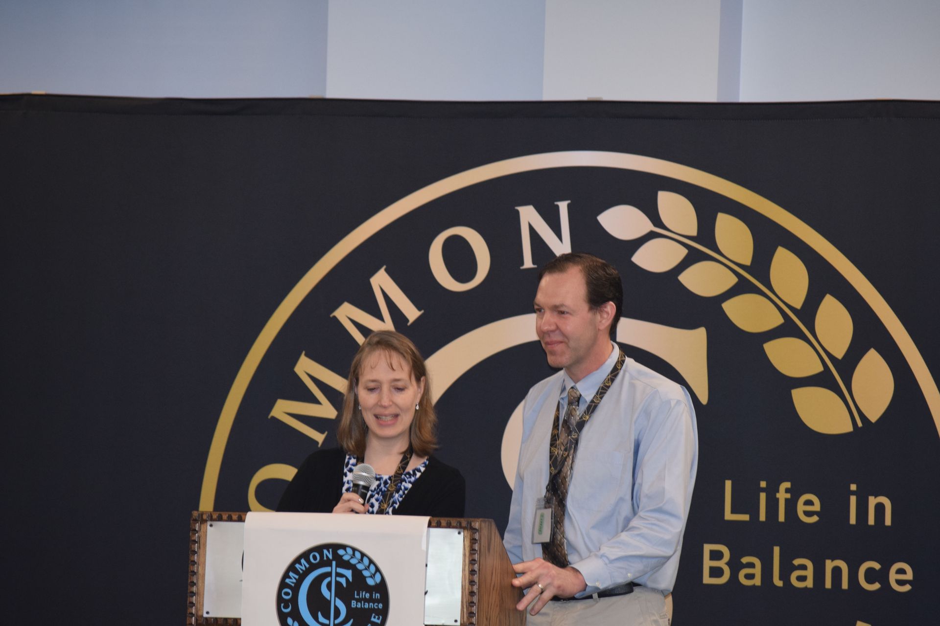 A man and a woman standing in front of a sign that says life in balance