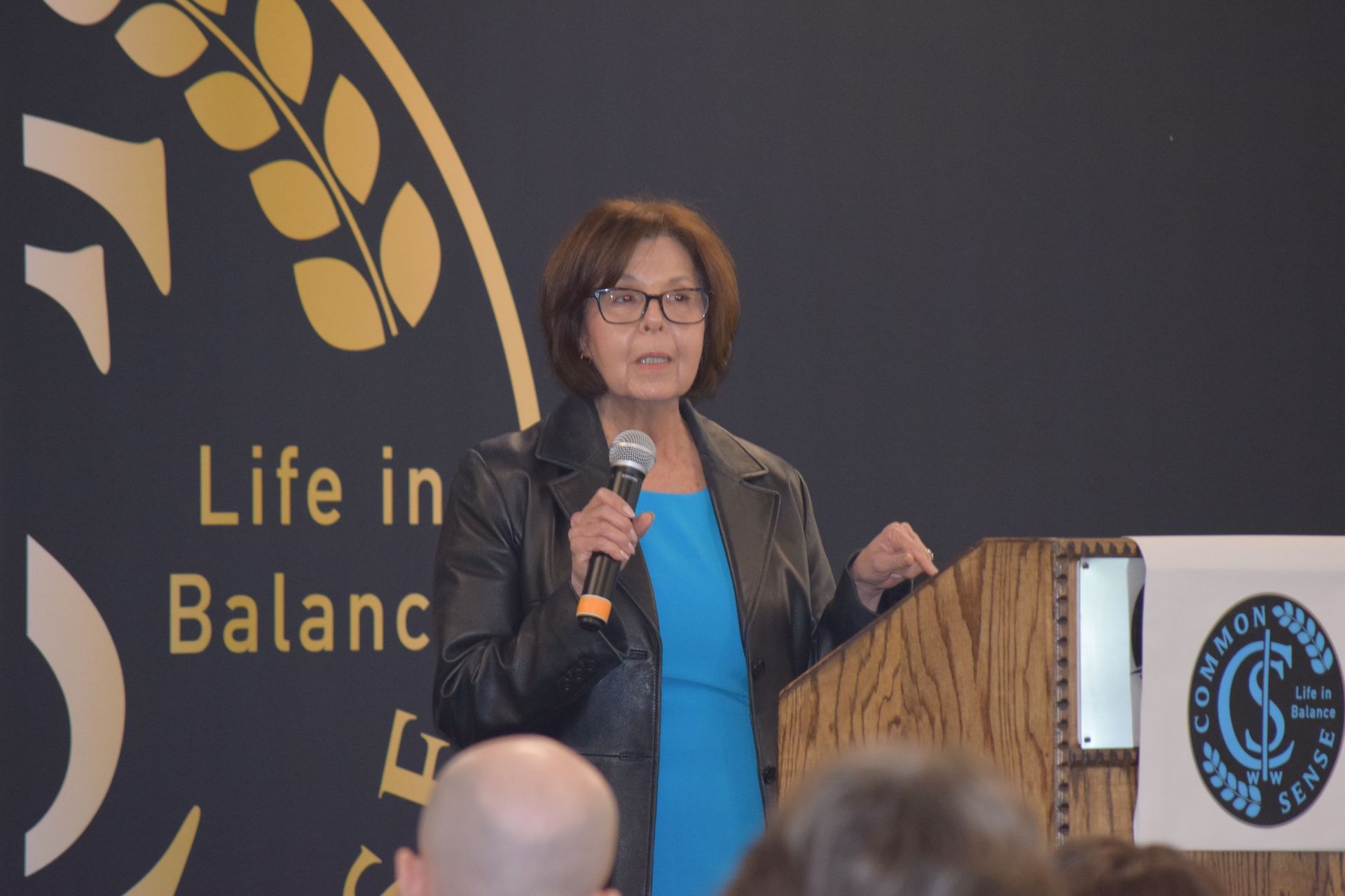 A woman is standing at a podium talking into a microphone.