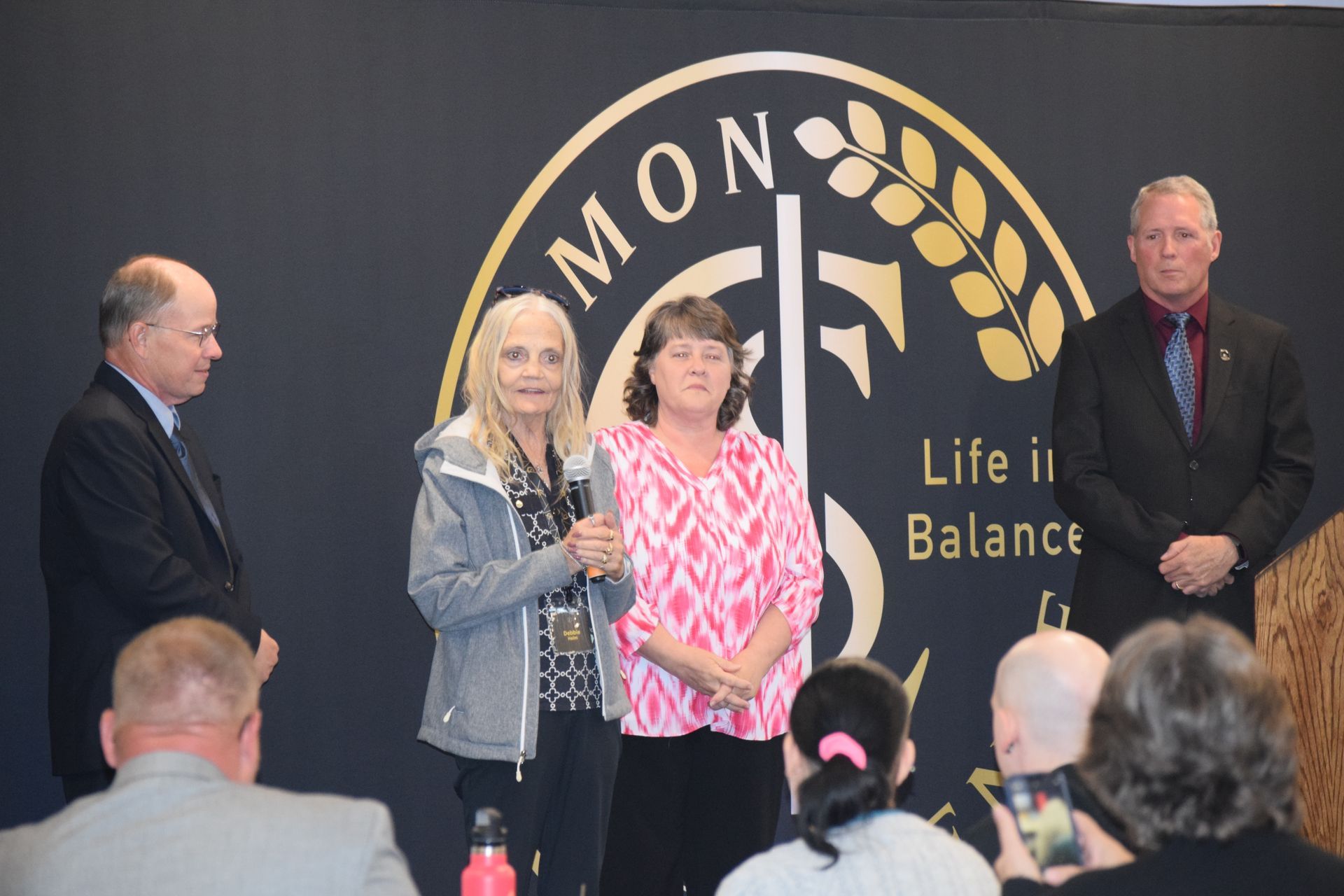 A group of people standing in front of a sign that says life in balance