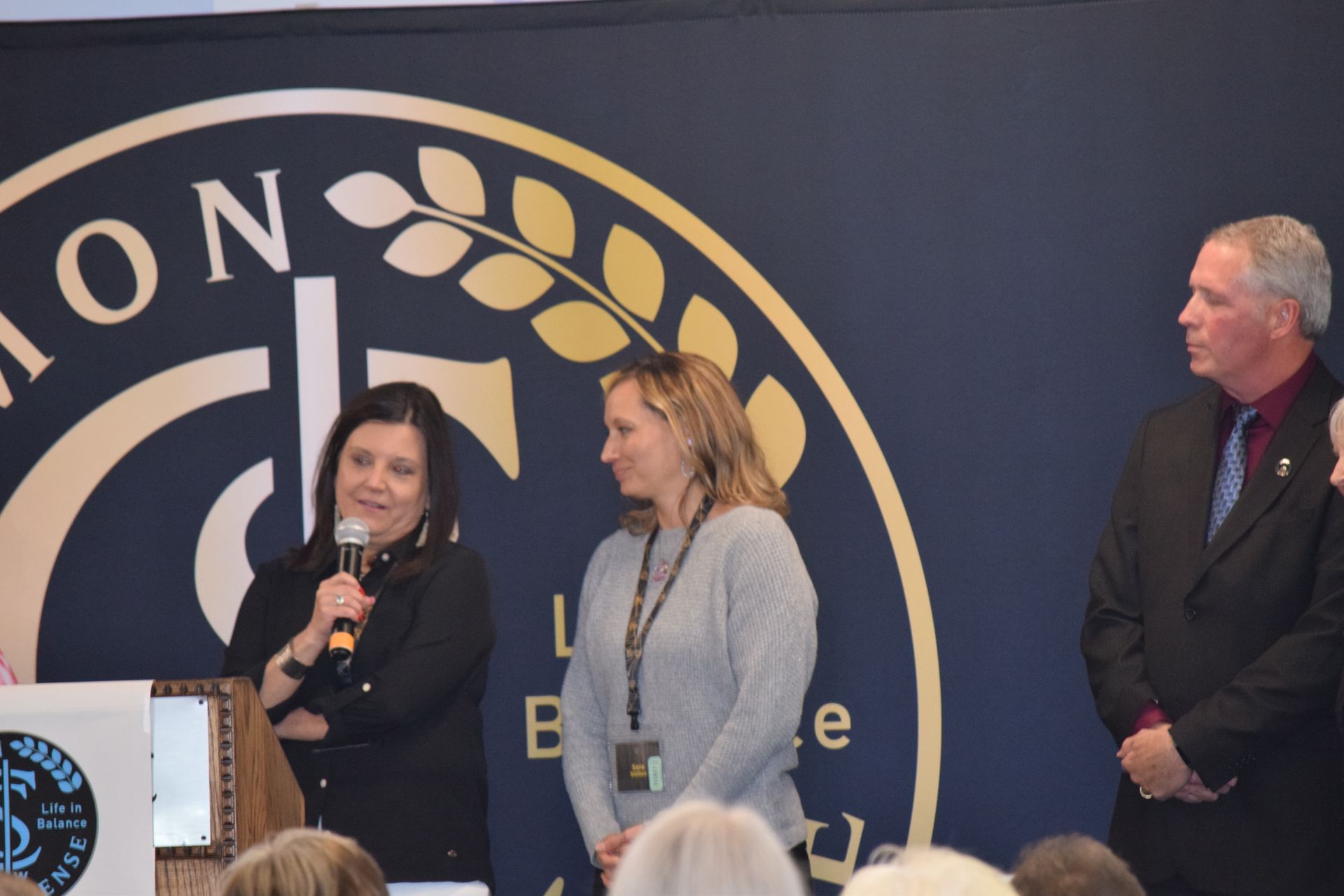 A group of people are standing in front of a podium.