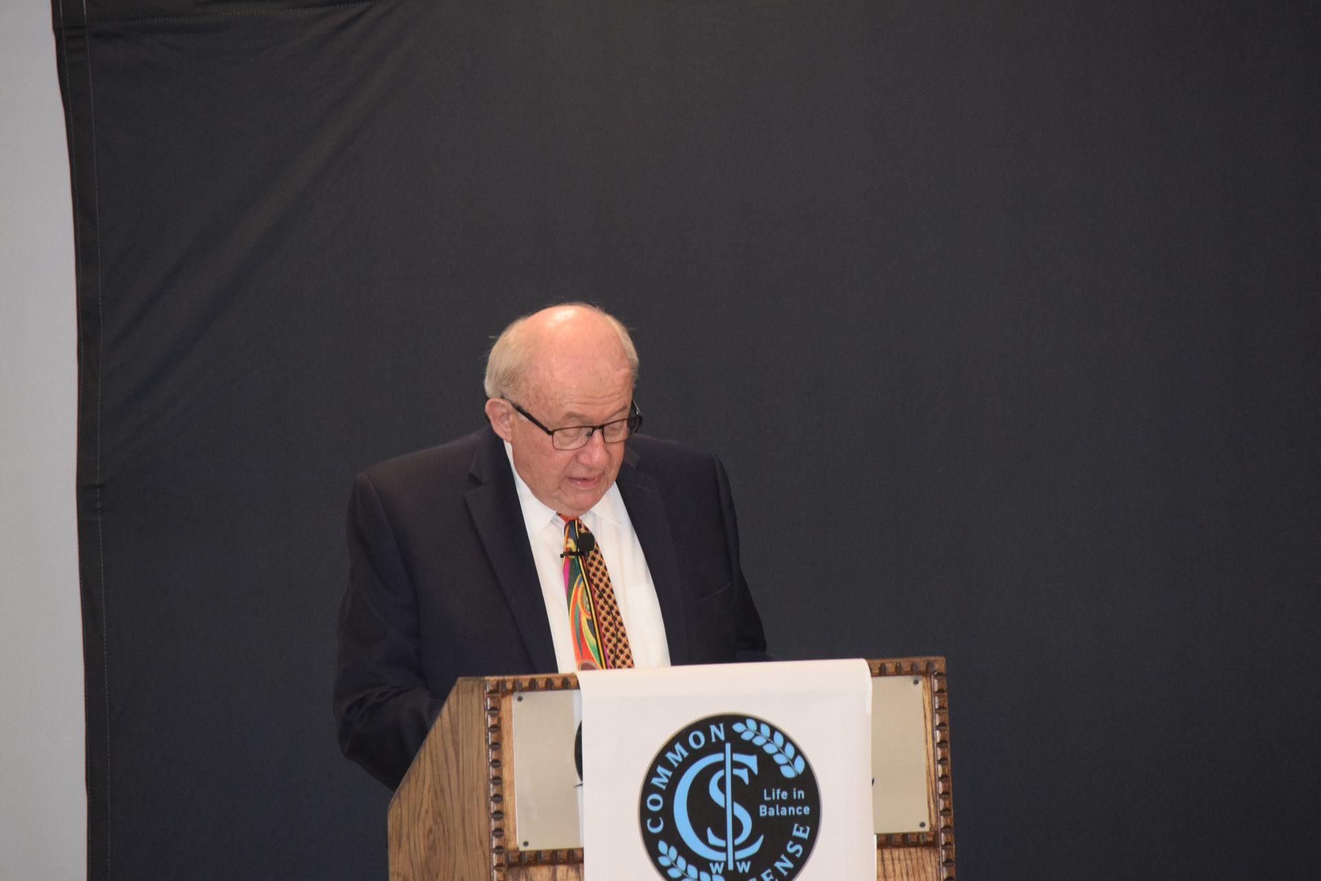 A man in a suit and tie is standing at a podium giving a speech.