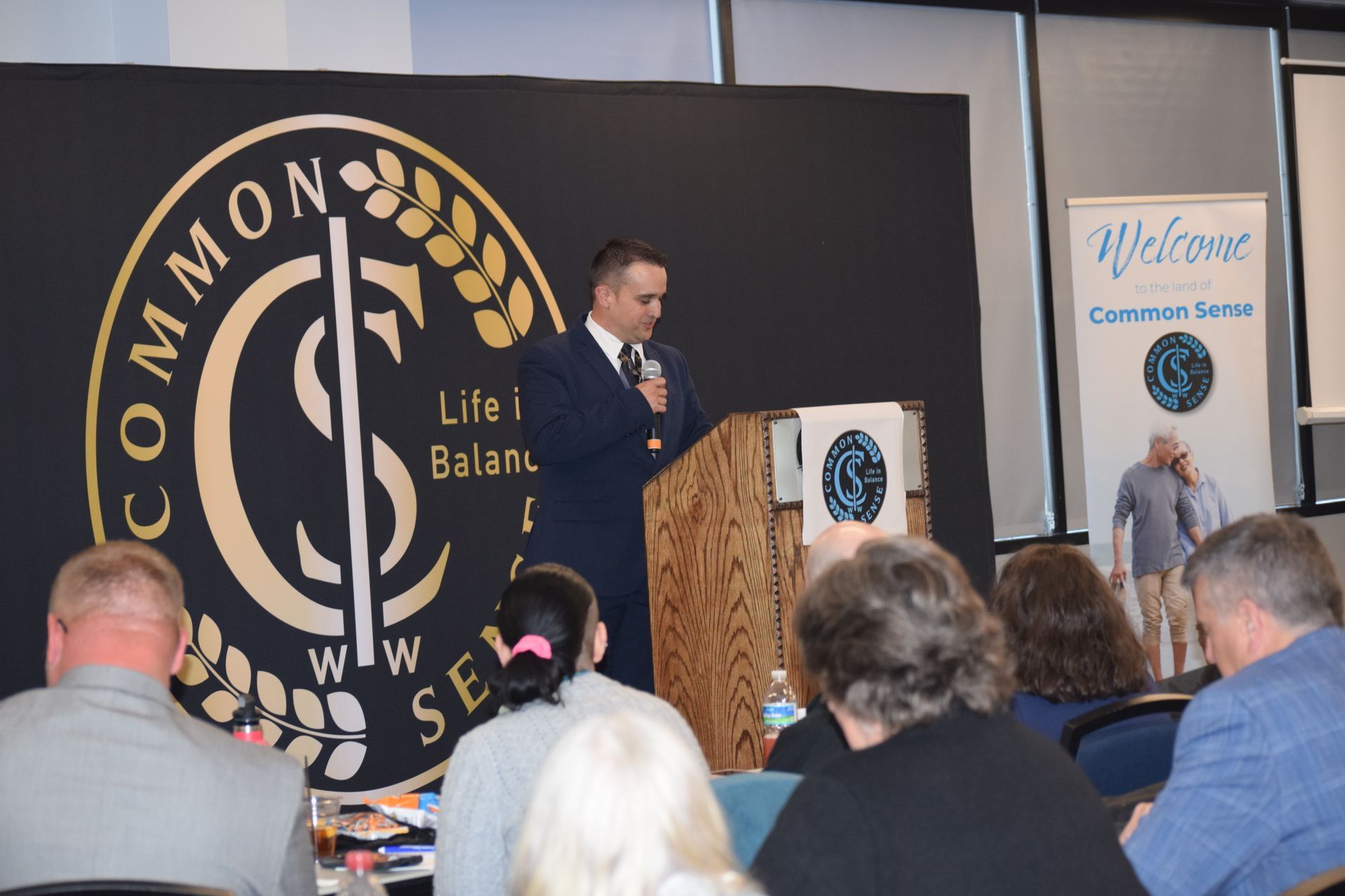 A man is standing at a podium giving a presentation to a group of people.