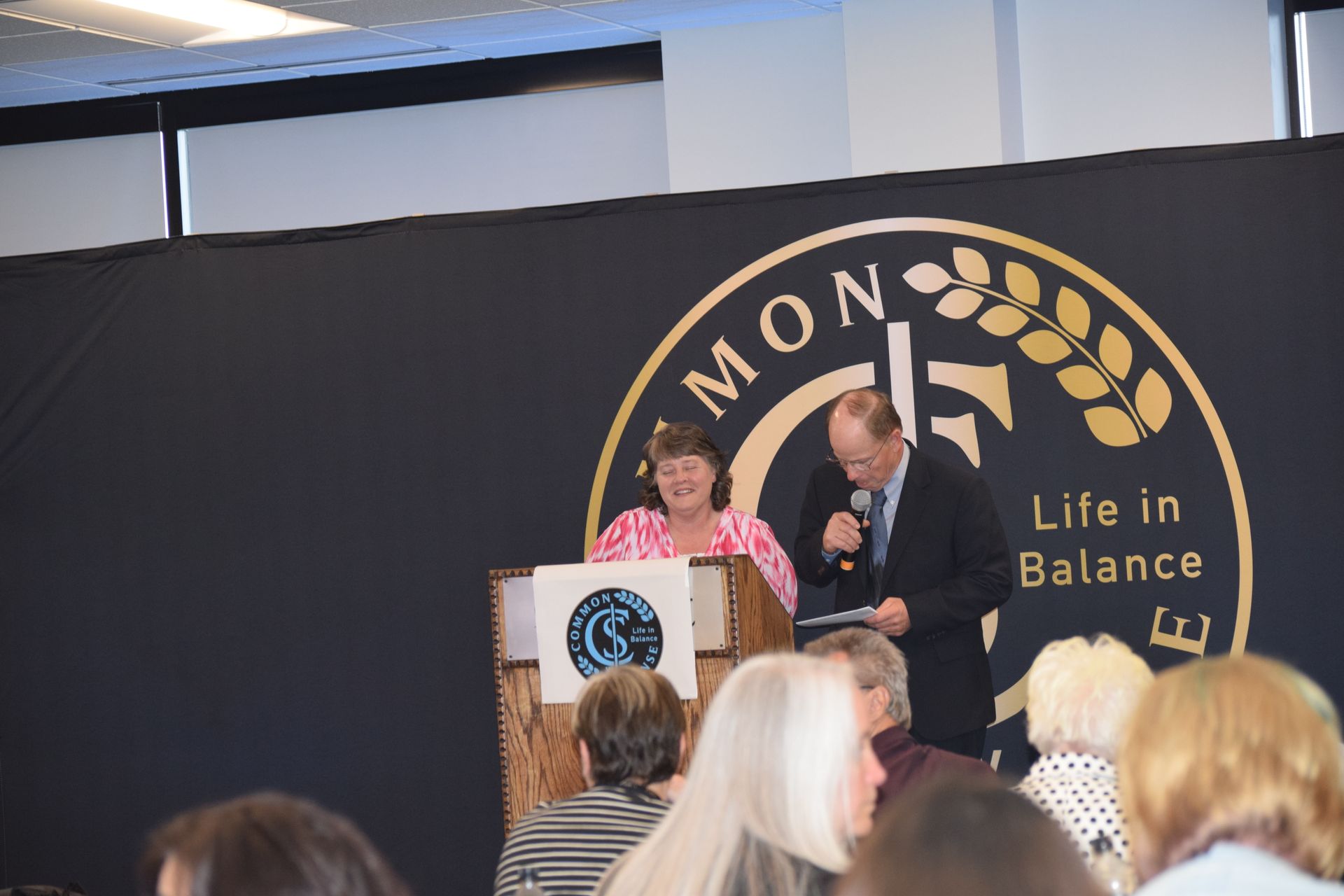 A group of people sitting in front of a sign that says life in balance