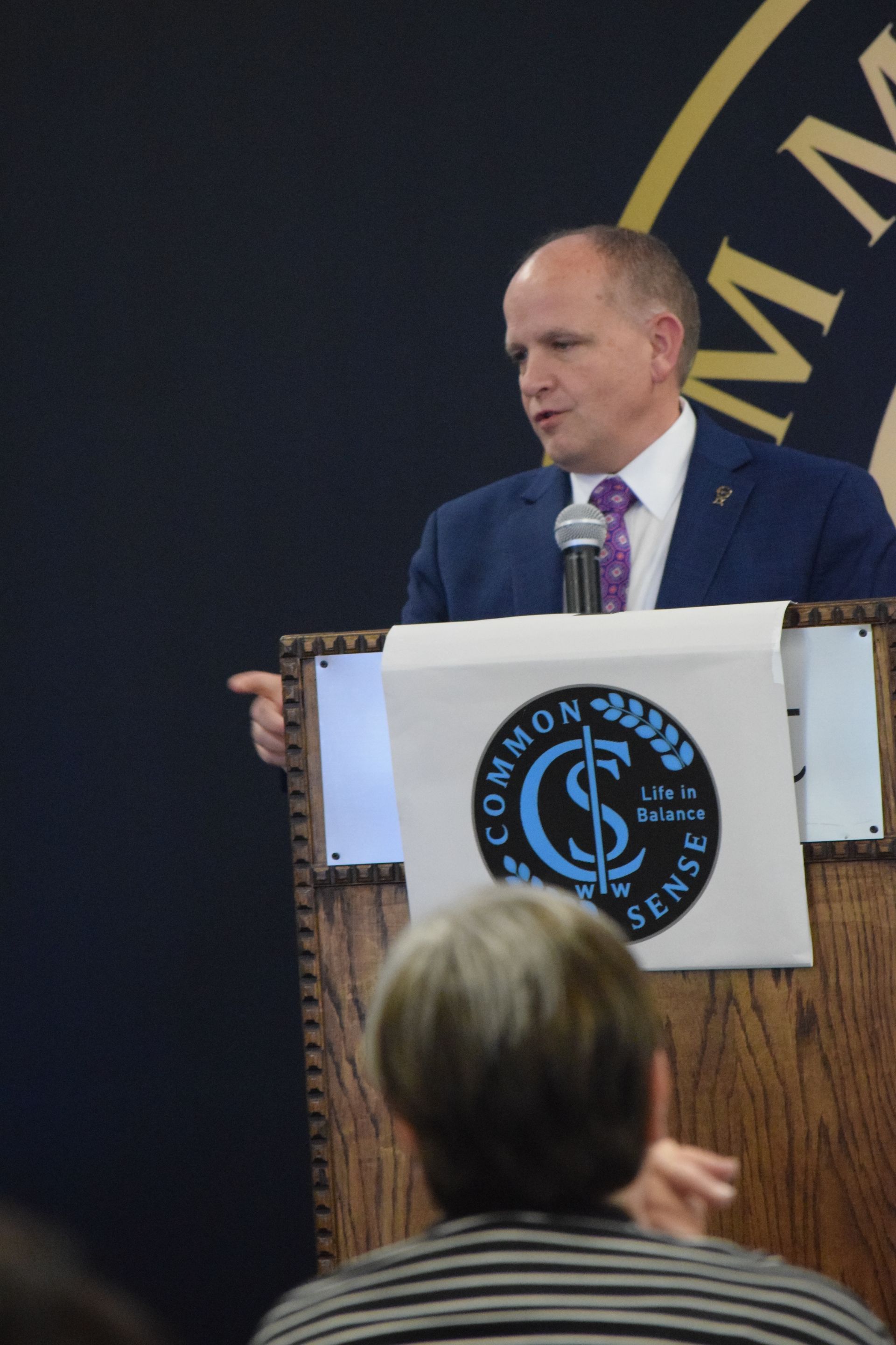 A man is giving a speech at a podium that says common sense
