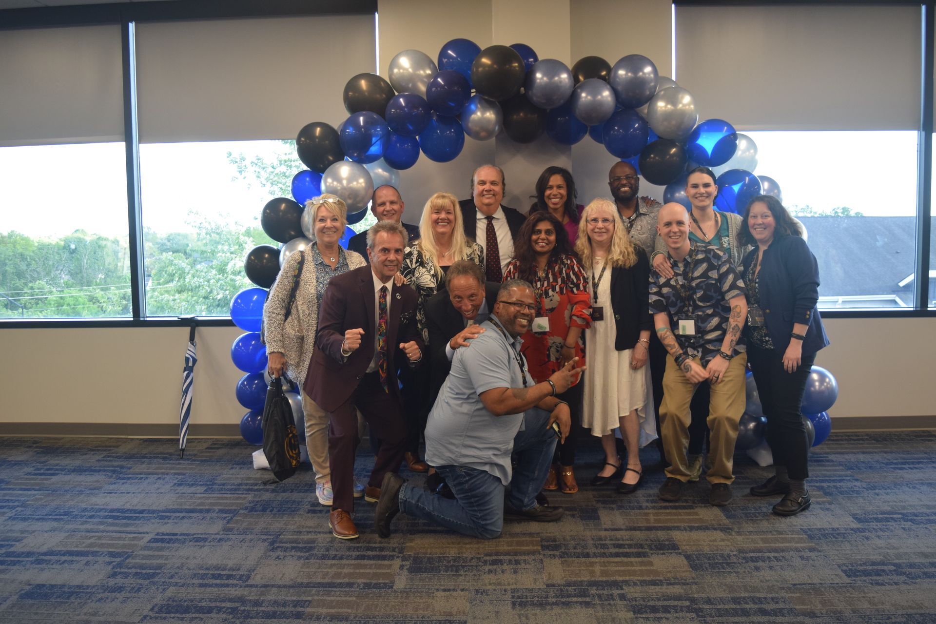 A group of people are posing for a picture in front of balloons.