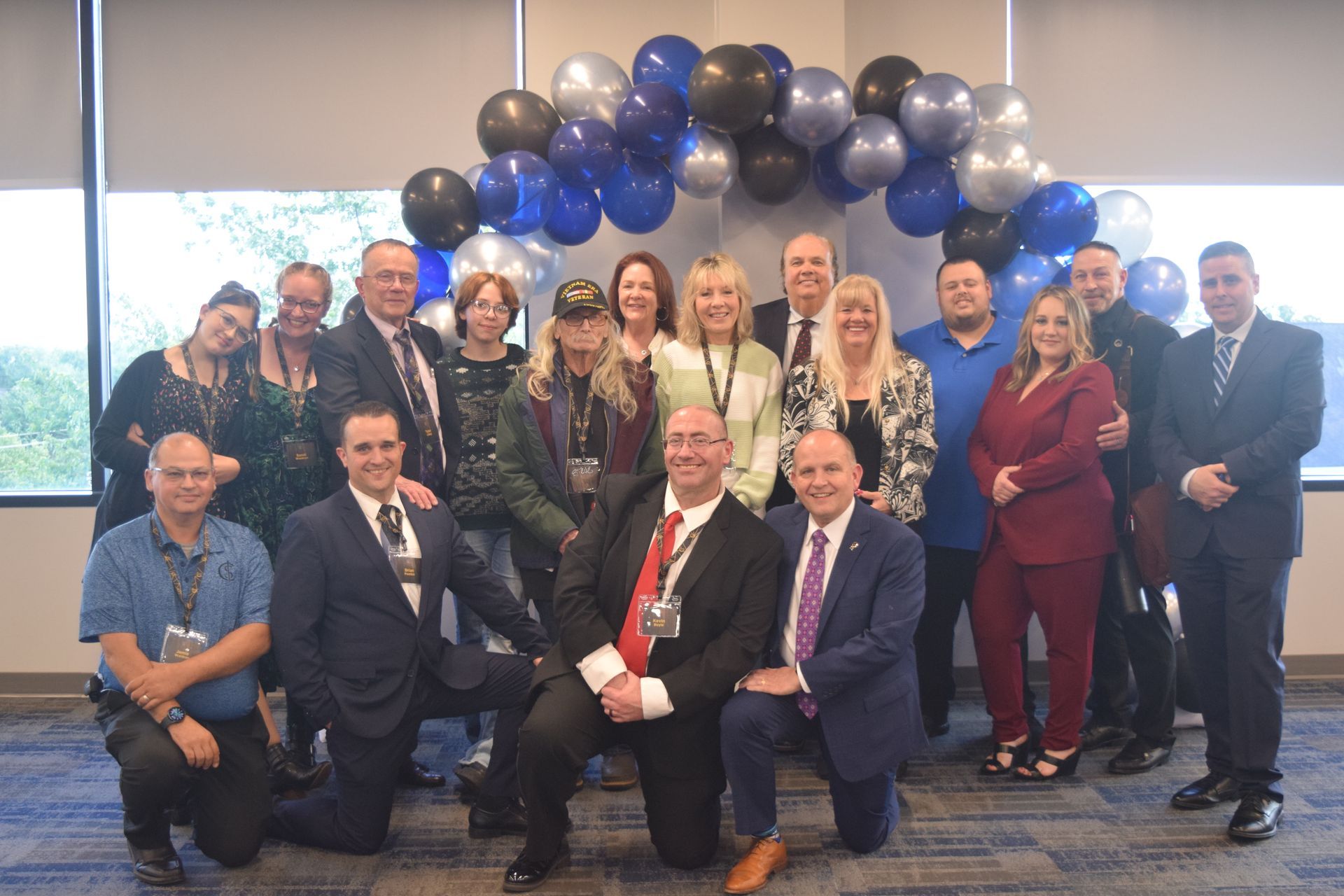 A group of people are posing for a picture in front of balloons.