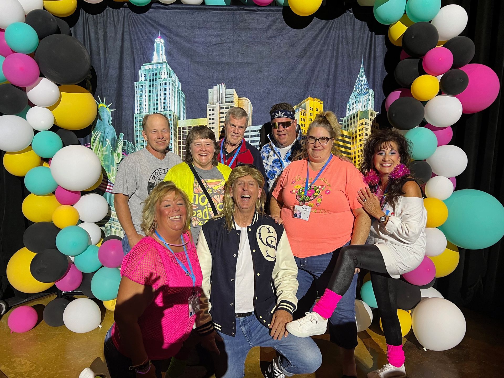 A group of people are posing for a picture in front of balloons.