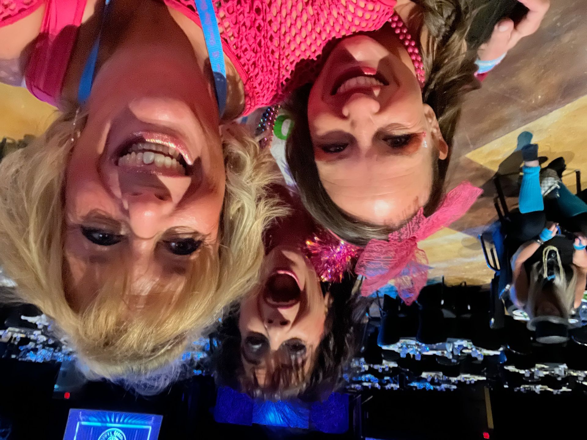 Three women are posing for a picture with their heads upside down